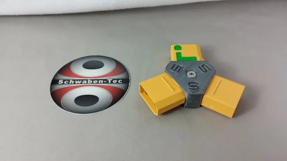 XT90-Steckerweiche Reihe Standard mit grauem Mittelstück und drei gelben Steckverbindern neben einem Aufkleber
