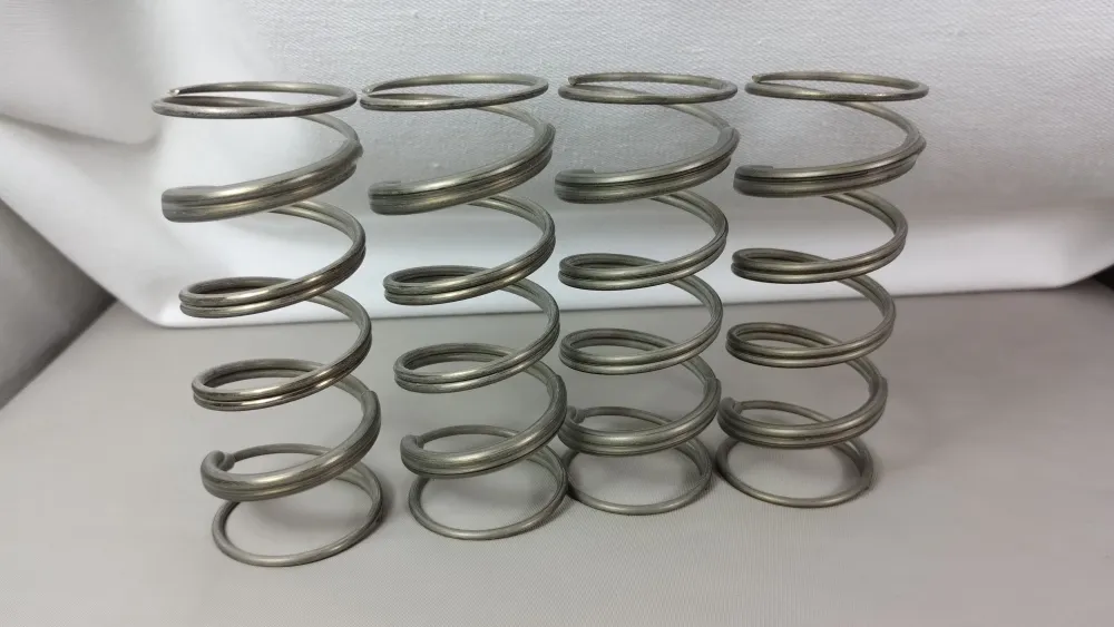 Vier silberfarbene Tuning-Federn für Losi DBXL 2.0 aufrecht nebeneinander