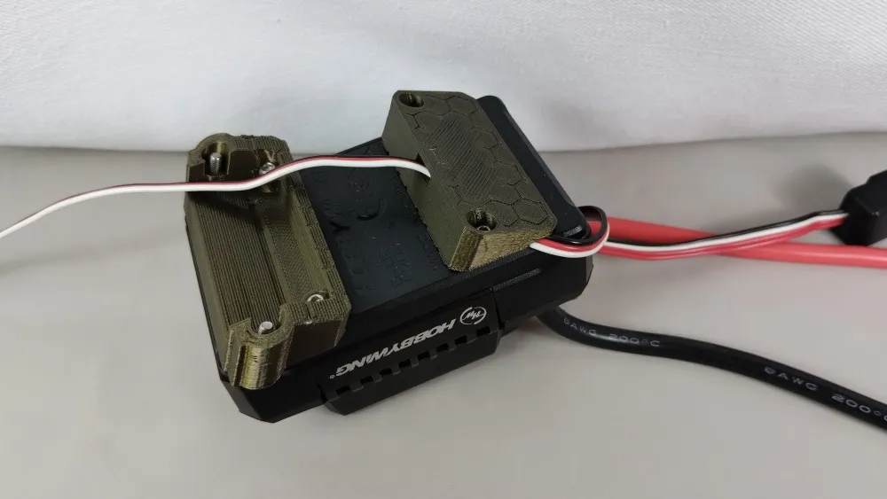 Unterseite eines Hobbywing-Reglers mit montierten olivfarbenen X-Maxx-Haltern und Befestigungsschrauben