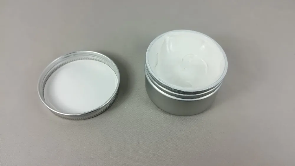 Geöffnete Metalldose Mikromos³ Visco X2 Diff Paste mit weißem Inhalt und danebenliegendem Deckel
