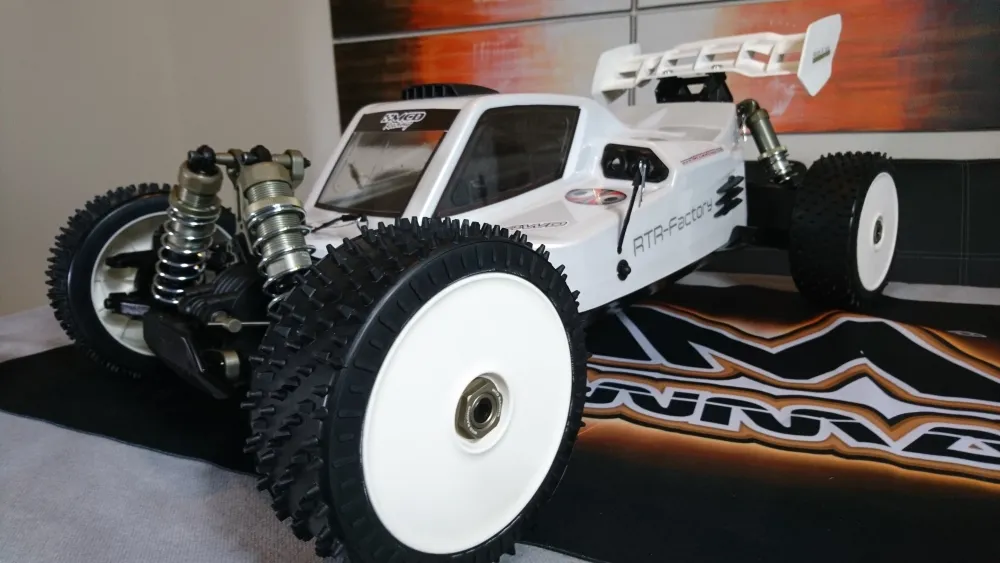 Weißer MCD RR5 Max Pro CF Buggy mit weißem Heckflügel und Scheibenrädern, schräg von vorn