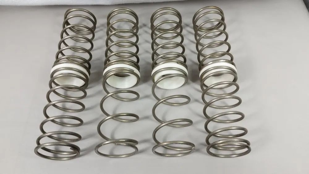 Acht Metallfedern des Traxxas X-Maxx Tuning-Feder-Sets LW in zwei Reihen ausgelegt