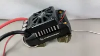 Hobbywing-Regler mit sichtbarem Lüfter auf olivfarbenen X-Maxx-Haltern, schräg von oben