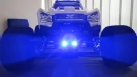 Traxxas X-Maxx frontal mit zwei hell blau leuchtenden LEDs unter dem vorderen Stoßfänger