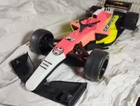 Serpent F190 mit rot-gelb-weißer Karosserie und schwarzen Kühlergrill-Einsätzen, schräg von vorn