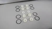 Weiße Einsätze, zwei Scheiben und acht schwarze O-Ringe des Traxxas UDR Fahrwerks 3.1