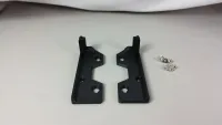 Zwei schwarze X-Maxx-Reglerhalter mit aufstehenden Laschen und danebenliegenden Befestigungsteilen, von oben